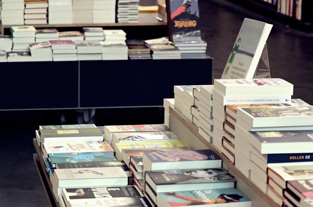 Interieur van een boekhandel in Rotterdam met boekenplanken en klanten die boeken uitzoeken